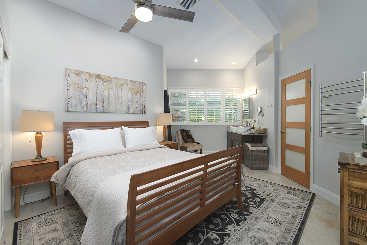 Wide view of the main bedroom with queen sized bed, dual night stands with lamps with large view window